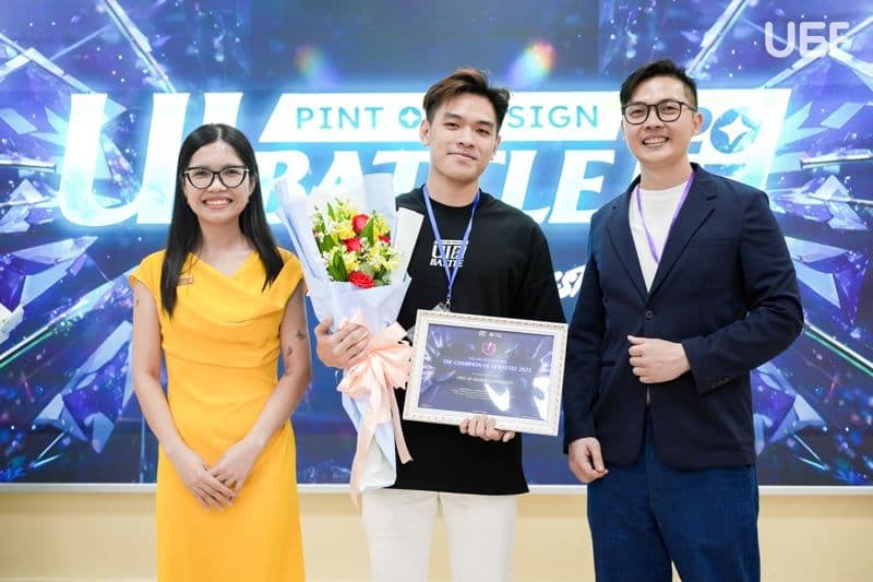 Kien Pham receiving the UI Battle champion award, with the two presenters