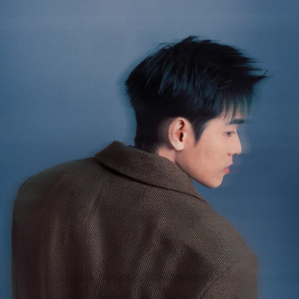 Artwork for một lần cười mười lần khóc by KIDEN: a portrait in a brown jacket against a blue background